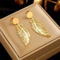 Gilded Plume Earrings in gold on a linen jewelry box