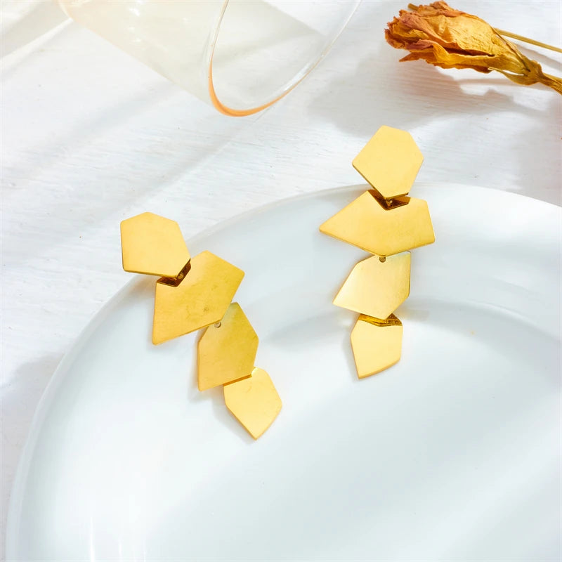 Golden Facet Drop Earrings on a white dish