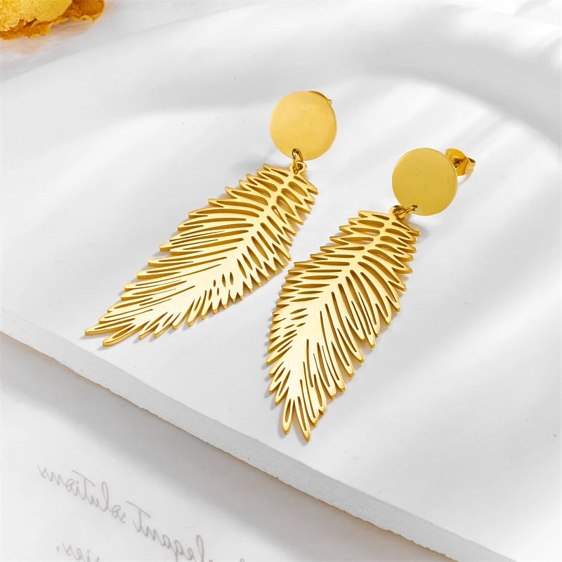 Gilded Plume Earrings resting on white paper